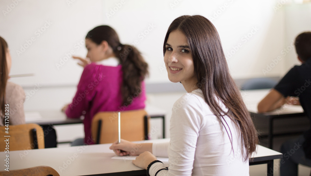 I will be a great student. Teenagers students sitting in the classroom and writing. Portrait of student girl. I will be a great student. Teenagers students sitting in the classroom and writing. Portrait of student girl.