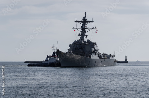WARSHIP - US Navy guided missile destroyer maneuvers in the port assisted by a tugboat