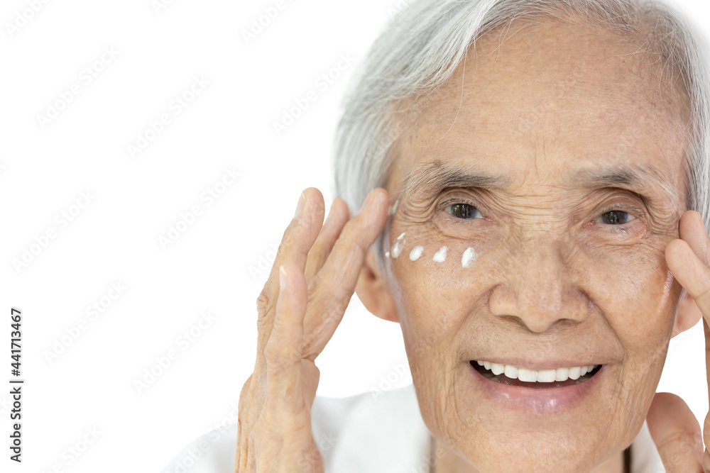 Obraz premium Close-up,Face of asian senior woman applying eye cream,anti-aging,nourishing under eye,facial treatment,happy smiling old elderly removing wrinkles crow's feet surrounding their eyes,skin care concept