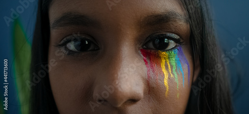 Close up shot of a young girl's eye with rainbow-colored tears representing the LGBTQ+ community