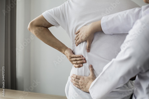 Slika na platnu Professional physiotherapists are working to relax the muscles for patients who are treated for muscle disorders, most patients are office workers who sit for a long time causing pain