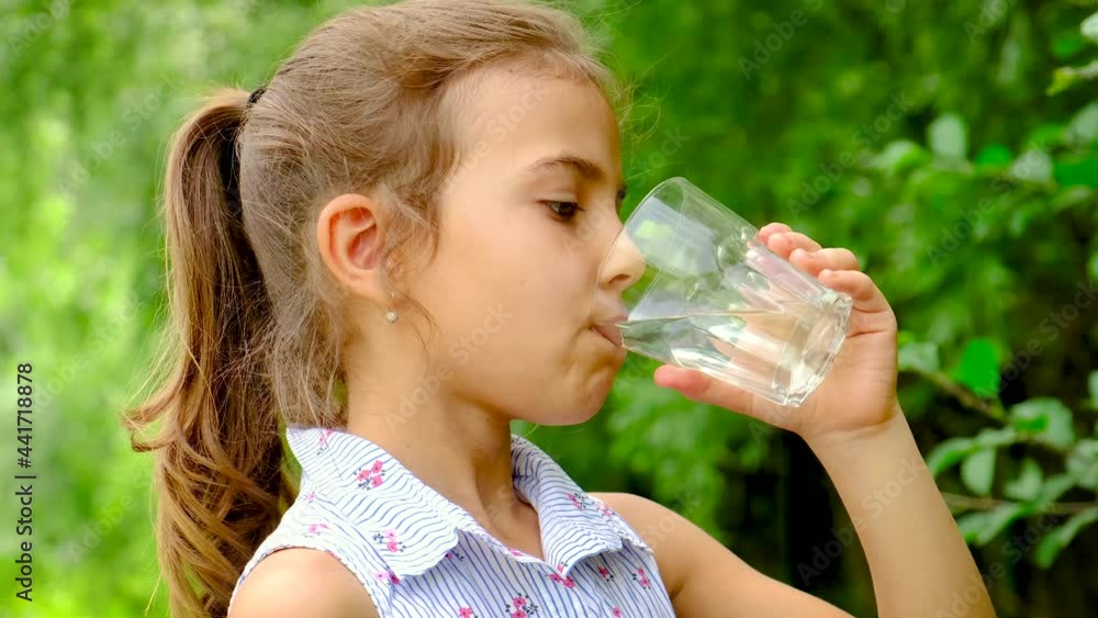 Child girl drinks water from a glass. Selective focus. Child girl drinks water from a glass. Selective focus.