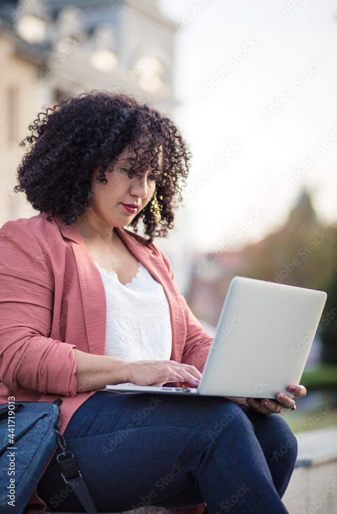 Business woman in the street using laptop. Business woman in the street using laptop.