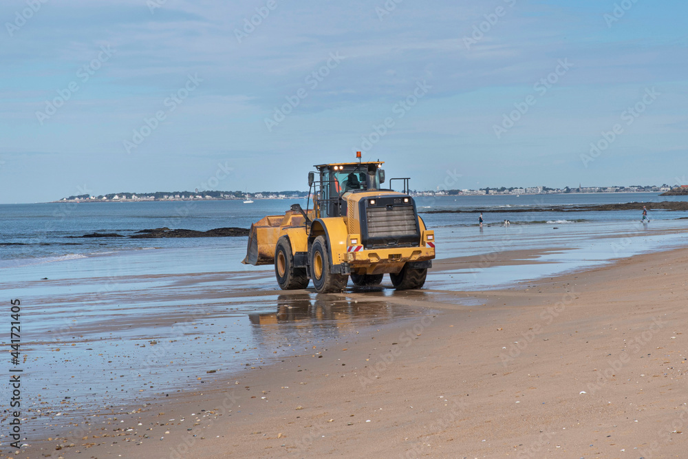 A construction excavator prepares a beach in Brittany for the arrival of tourists
A construction excavator prepares a beach in Brittany for the arrival of tourists