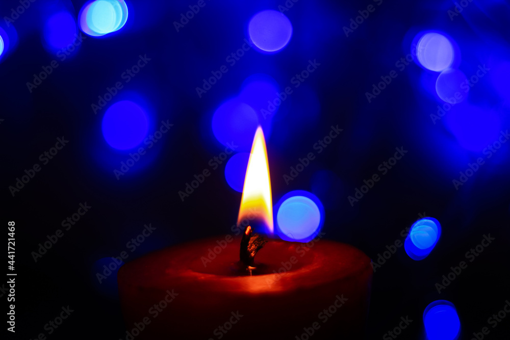 Candle lights in darkness with colorful light effects and bokeh for