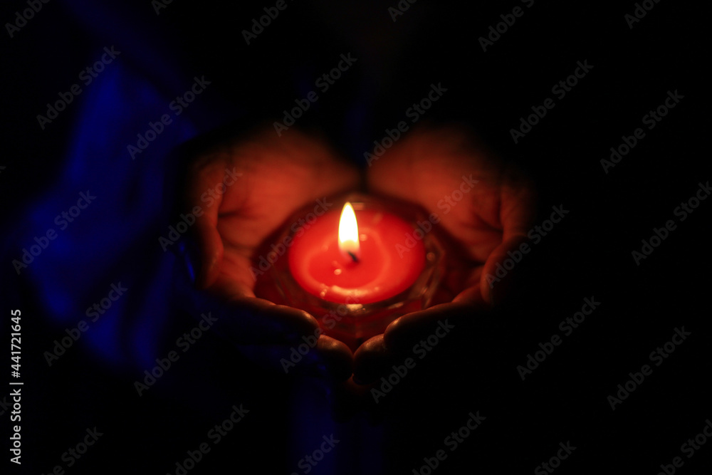 Burning candle in the hands of a girl. Christmas candles. Candle light glowing in woman's hands. Praying, faith, religion concept. Burning candle in the hands of a girl. Christmas candles. Candle light glowing in woman's hands. Praying, faith, religion concept.
