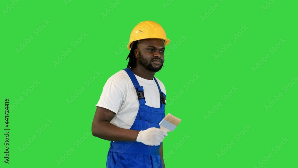 Man holding a paint brush and a paint bucket walking and looking around what to paint on a Green Screen, Chroma Key. Man holding a paint brush and a paint bucket walking and looking around what to paint on a Green Screen, Chroma Key.