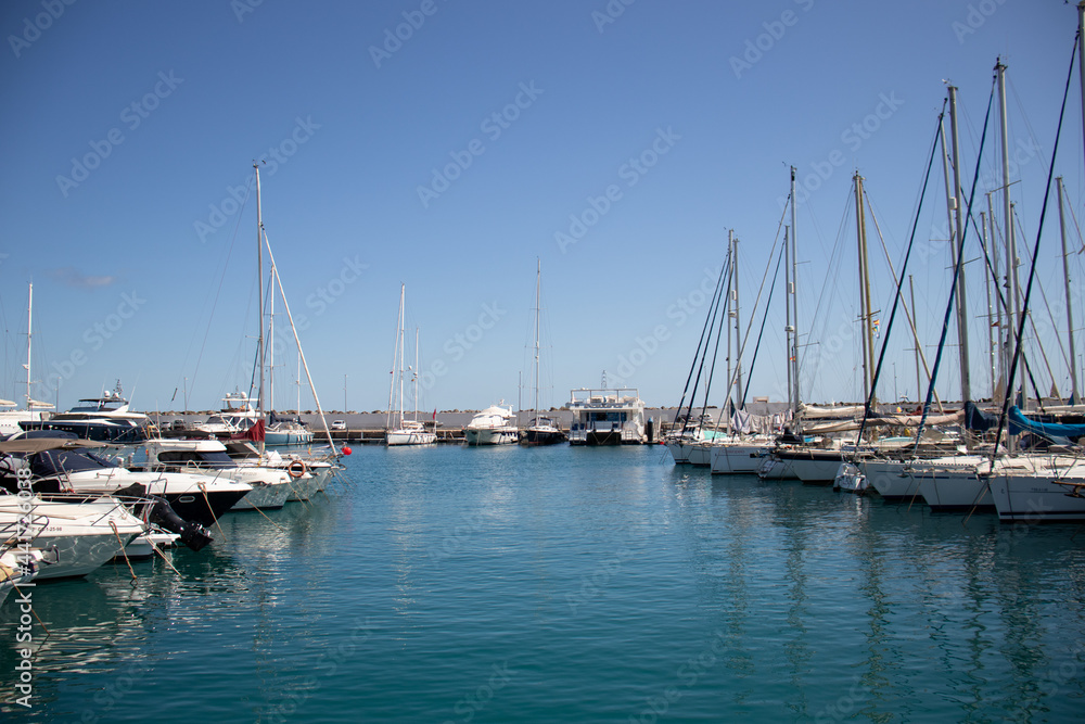 View of the jetty with small fishing and recreational boats in the marina of Las Palmas de Gran Canaria, with the industrial port in the background.