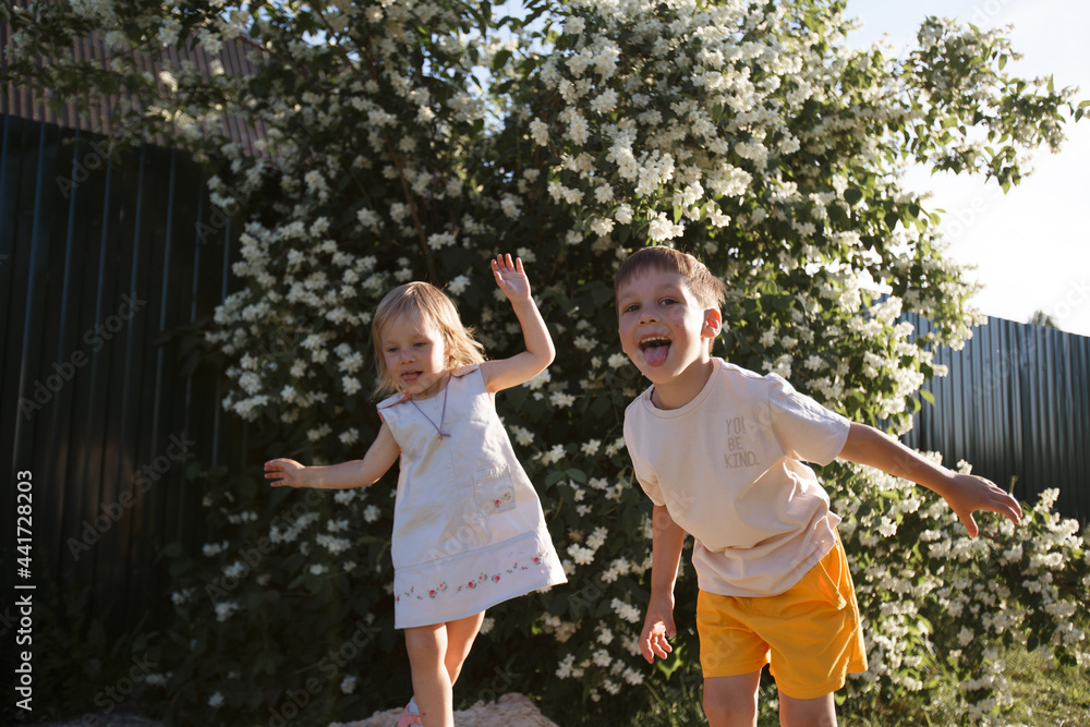 Obraz premium brother and sister play together on the street and make faces