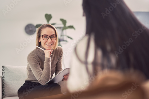 Smiling female psychologist listening to client during session
