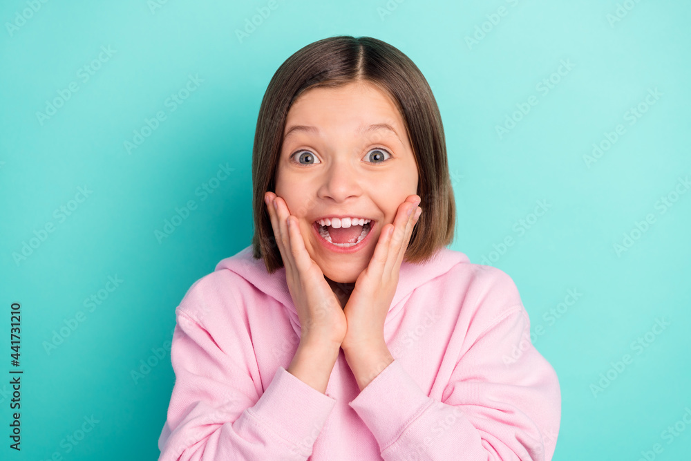 Photo of short hairdo joyful small girl hands face wear pink sportswear isolated on teal color background Photo of short hairdo joyful small girl hands face wear pink sportswear isolated on teal color background