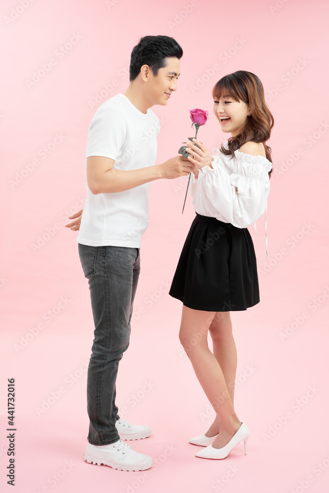 Handsome man giving red rose to his surprised girlfriend. Handsome man giving red rose to his surprised girlfriend.