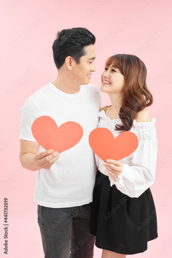 Young beautiful asian couple with present isolated on pink
