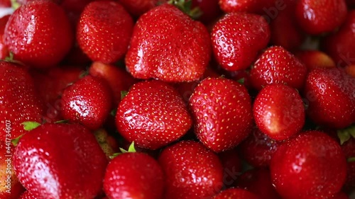 Ripe juicy strawberries slowly rotate. Summer harvest of sweet berries. Background of fresh delicious fruits