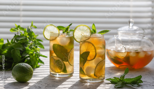 Iced tea with mint and lime iced. Cooling summer drink.