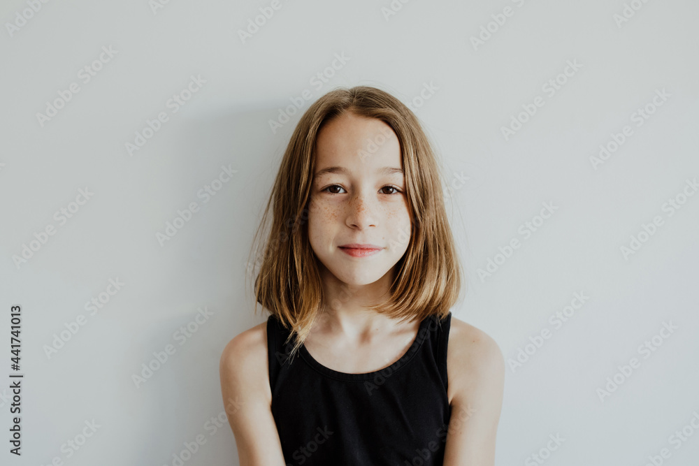 Pensive teen girl looking at camera against white background Pensive teen girl looking at camera against white background