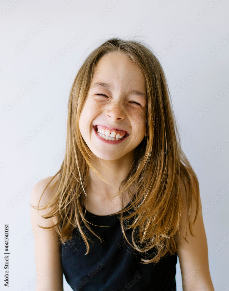 Happy girl with long hair and freckles against white background Happy girl with long hair and freckles against white background