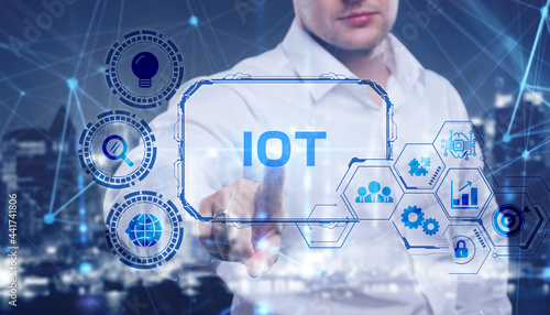 Internet of things - IOT concept. Businessman offer IOT products and solutions. Young businessman select the abstract chip with text IoT on the virtual display
