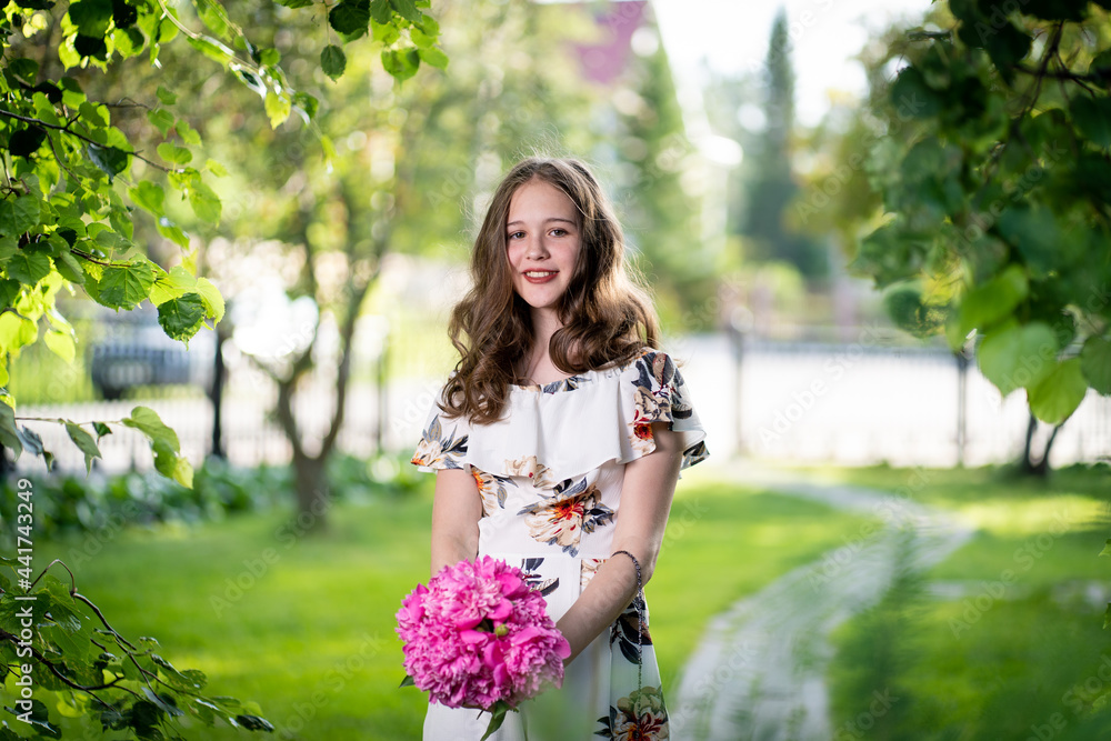 cheerful girl in a light summer dress against the background of a city park cheerful girl in a light summer dress against the background of a city park