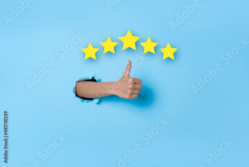 Fotografi Customer Experience Woman hand thumb up vote on five star excellent rating on blue background