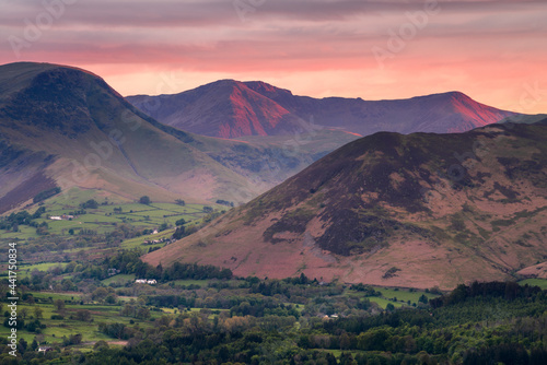 Scenic views of Lake District mountains with beautiful sunset in sky. British mountain landscape with dramatic evening light. Keswick, Lakeland, UK.