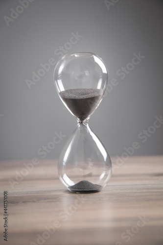Hourglass on the wooden desk.