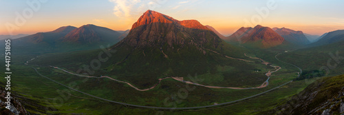 Obraz na płótnie Panorama of Glencoe mountain range covered in beautiful golden light from the evening sun
