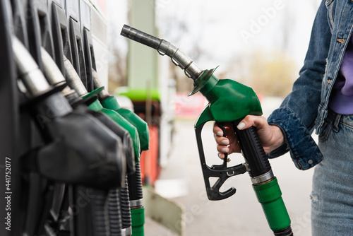 Canvastavla cropped view of woman holding petrol pistol on gas station