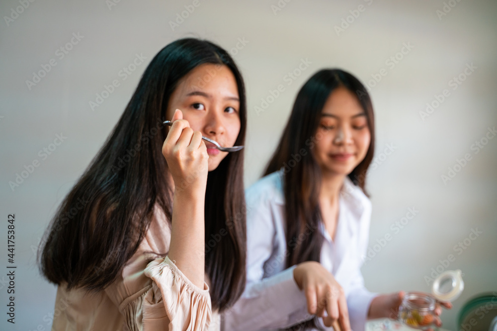 Young female asian women friends cooking in kitchen preparing together meal Young female asian women friends cooking in kitchen preparing together meal