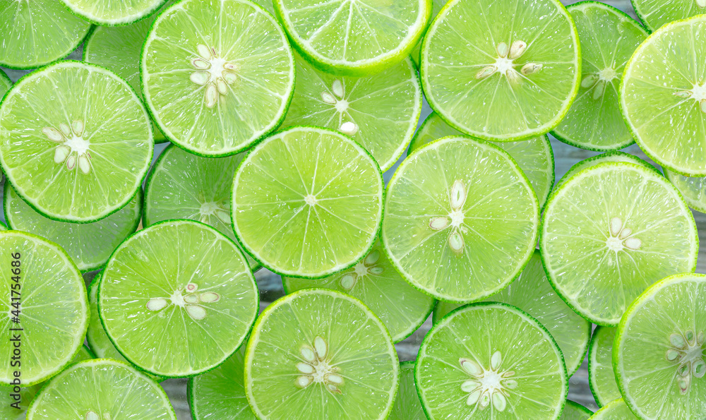 Lime slices background,Lemon and green lime overlapped slices close-up background,Macro close up surface texture Juicy slice of lime Lime slices background,Lemon and green lime overlapped slices close-up background,Macro close up surface texture Juicy slice of lime