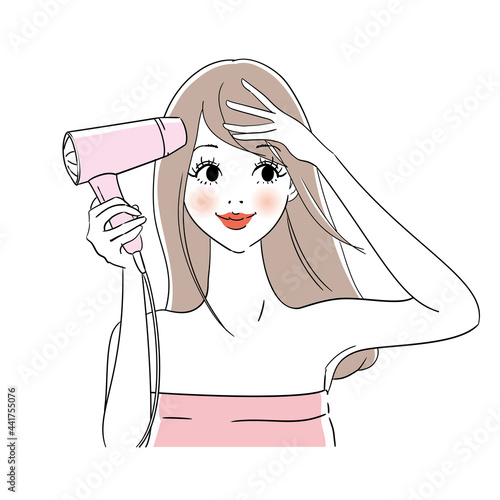 ドライヤーで髪を乾かす女性
