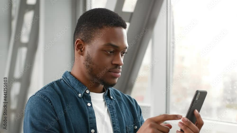 African American Guy Using Phone With Travel Application In Airport African American Guy Using Phone With Travel Application In Airport