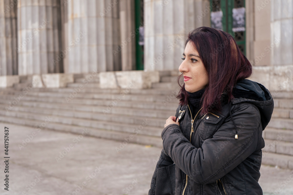 Fototapeta premium Outdoor portrait of young pretty beautiful woman in cold cloudy winter weather.