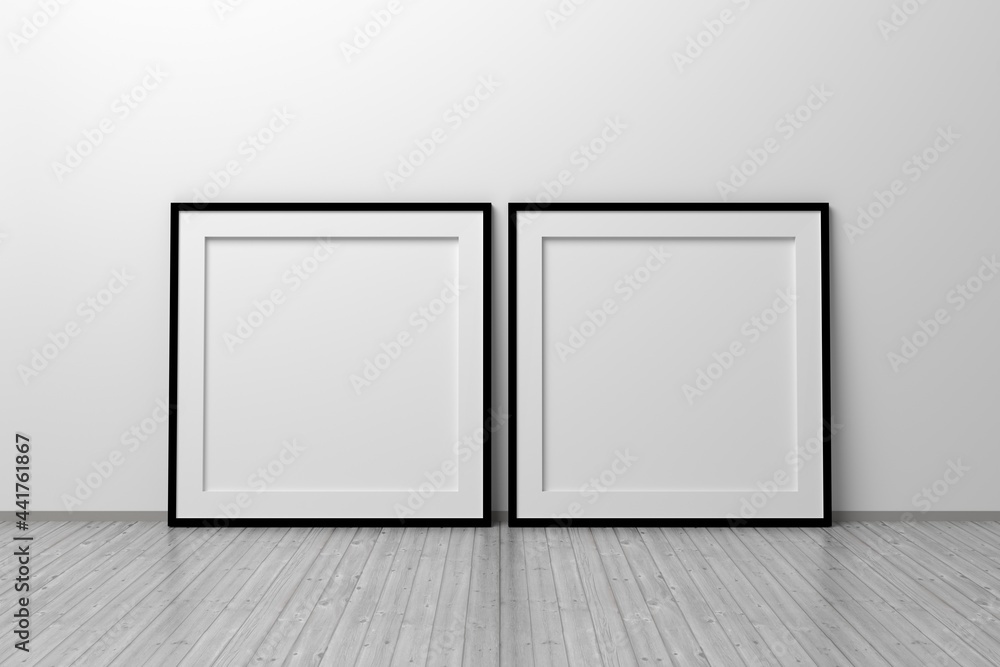Mockup template of two square frames with thin black frame border standing next to wall on wooden floor Mockup template of two square frames with thin black frame border standing next to wall on wooden floor