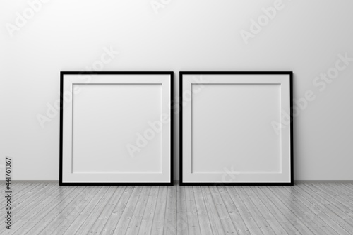 Mockup template of two square frames with thin black frame border standing next to wall on wooden floor © dariaren