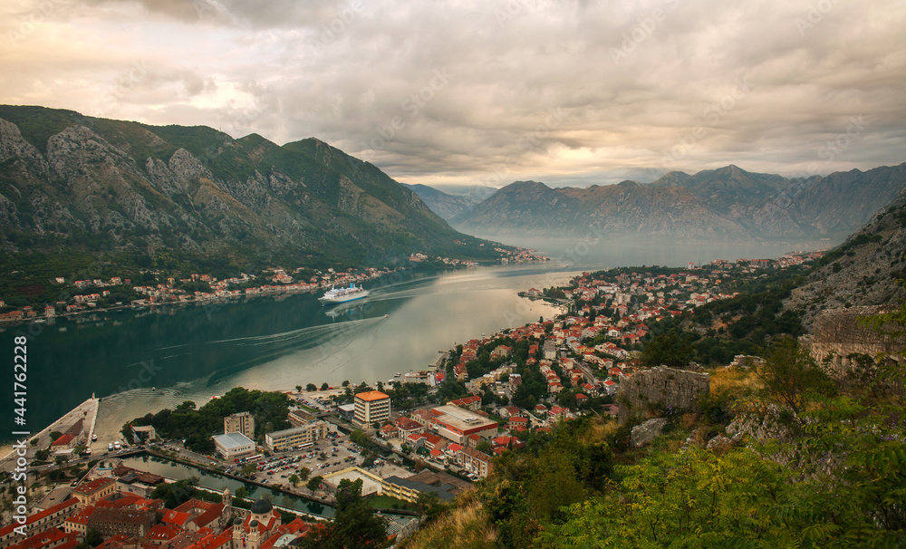Ancient fortress on background of famous tourist town Kotor Bay mountains and sky, aerial view Montenegro