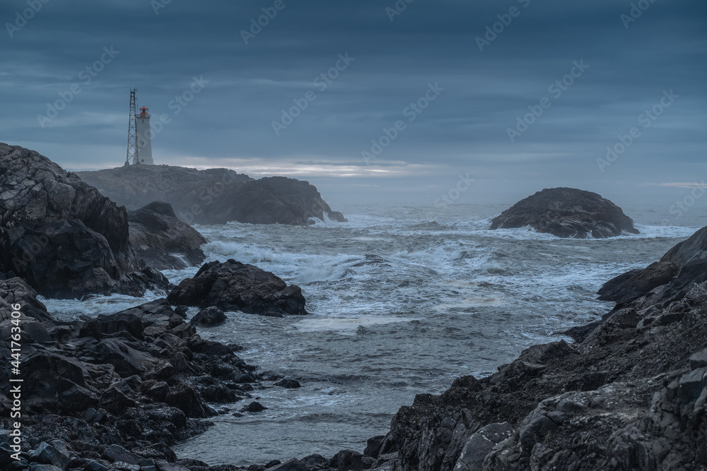 Lighthouse at Stokksnes coast in East Iceland ocean coastline. Dramatic moody landscape