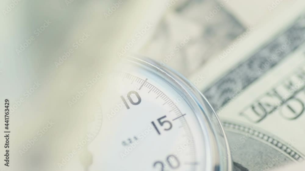 Dollar banknotes flying over the stopwatch dial. Dollar banknotes flying over the stopwatch dial.