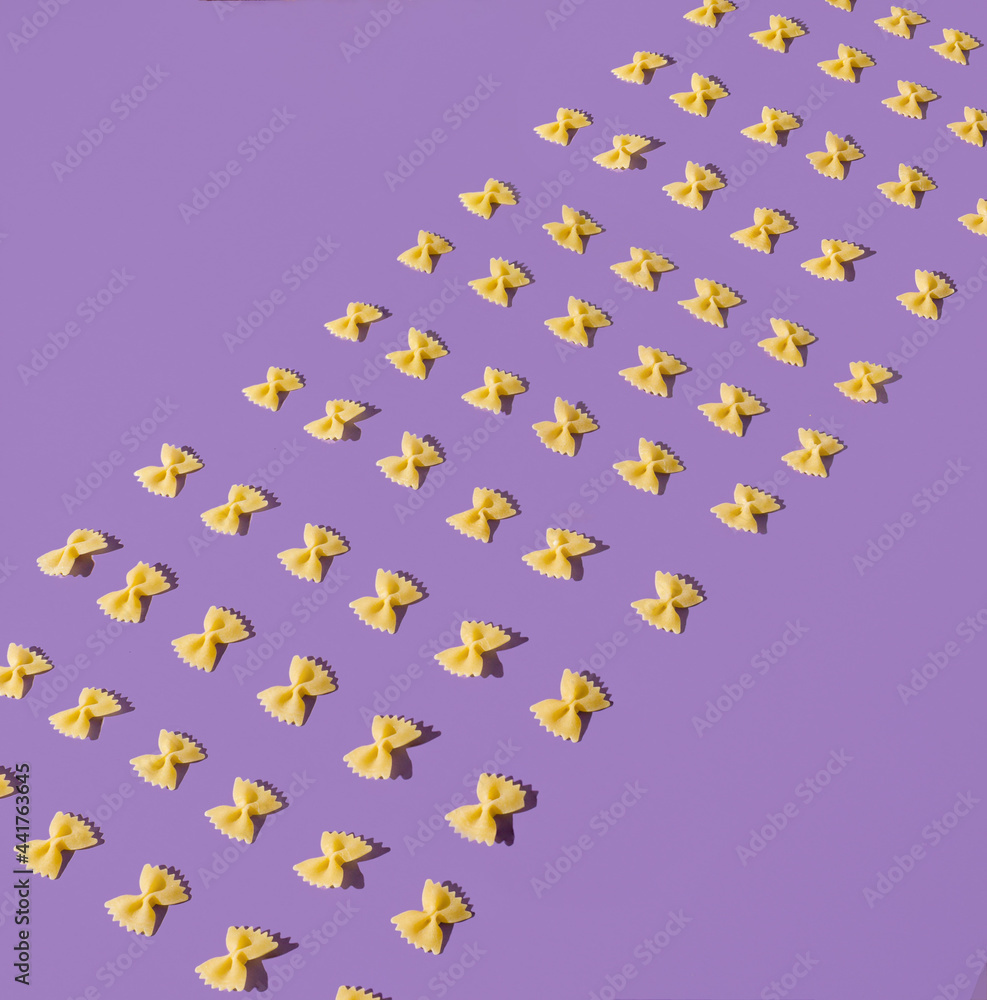Creative layout of farfalle pasta. Fun and bright food concept. Bow tie shaped macaroni. Creative layout of farfalle pasta. Fun and bright food concept. Bow tie shaped macaroni.