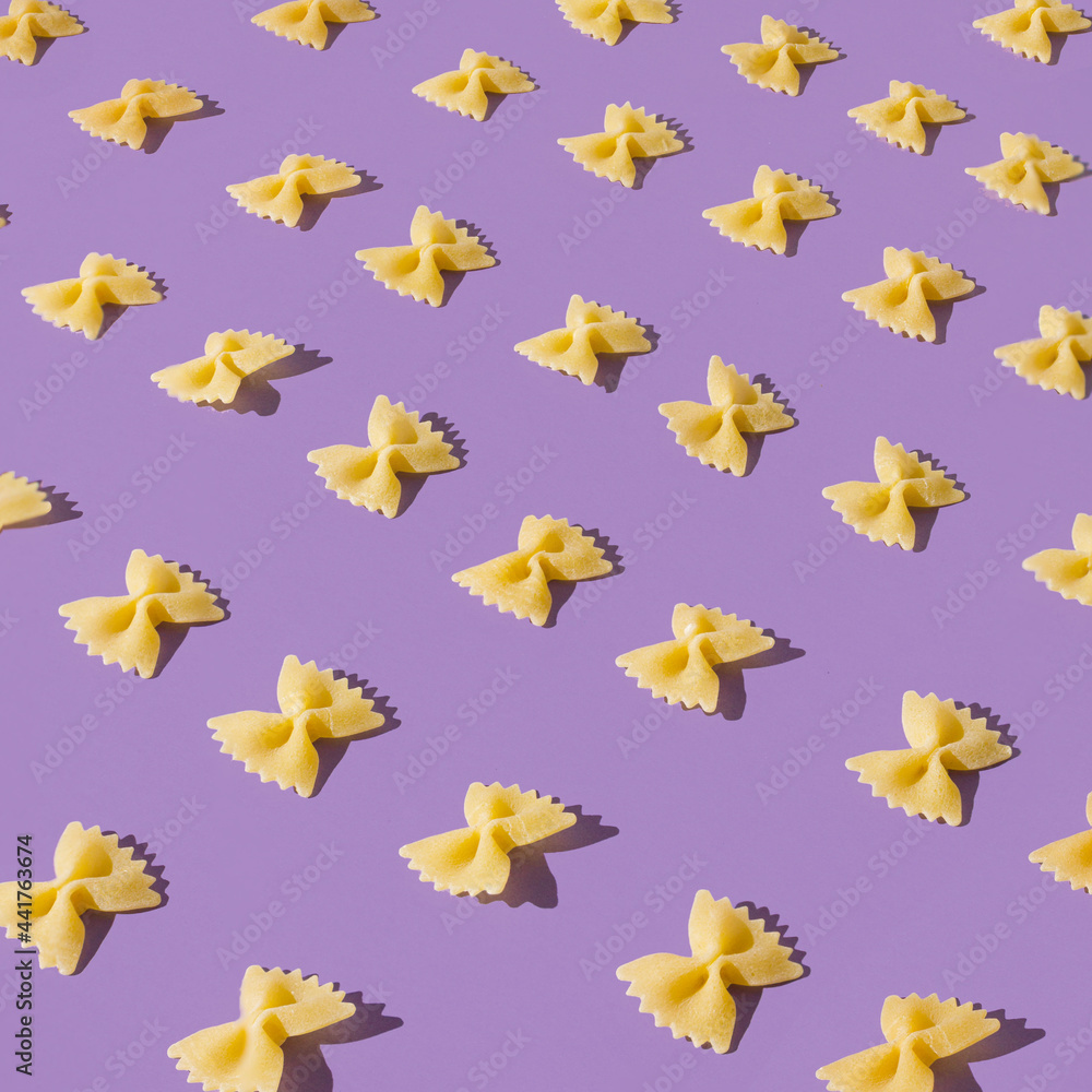 Flat lay pattern of farfalle pasta. Fun and bright food concept. Bow tie shaped macaroni. Flat lay pattern of farfalle pasta. Fun and bright food concept. Bow tie shaped macaroni.