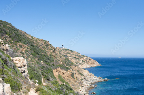 Revellata lighthouse on a hill in Corsica, France under a clear blue sky photo