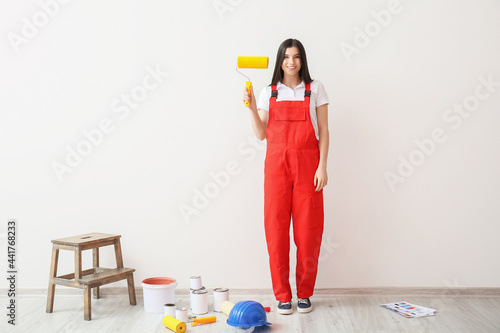 Young woman with paint roll...