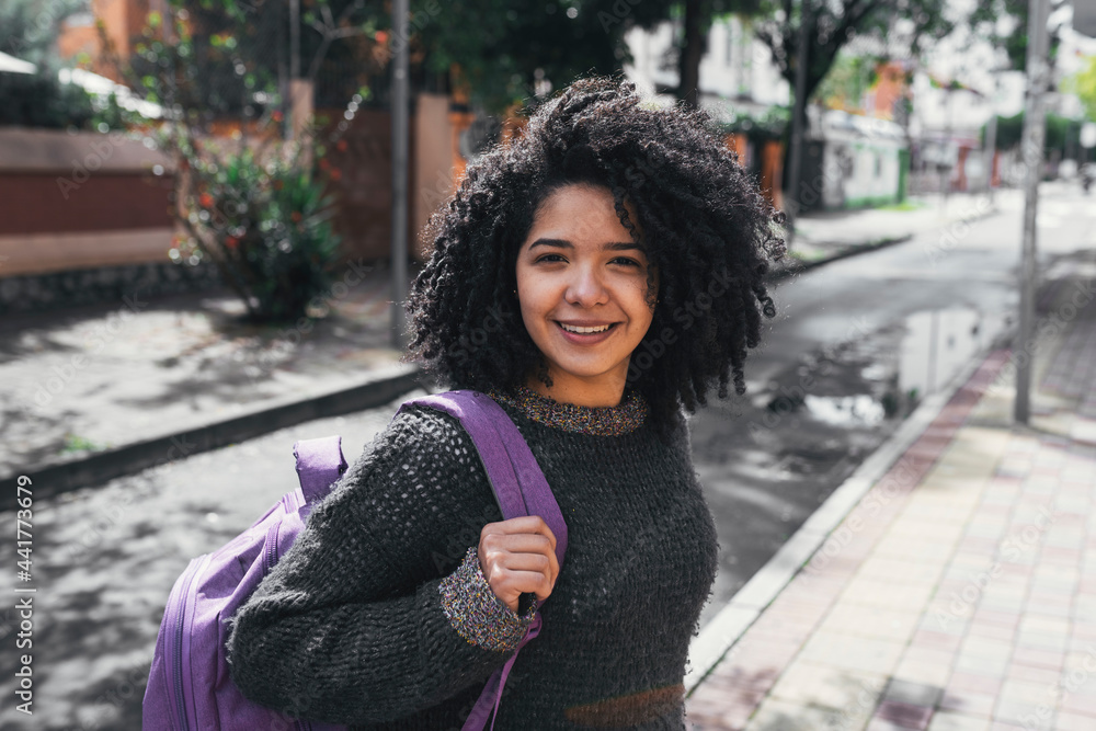 Smiling ethnic woman with backpack in city street Smiling ethnic woman with backpack in city street