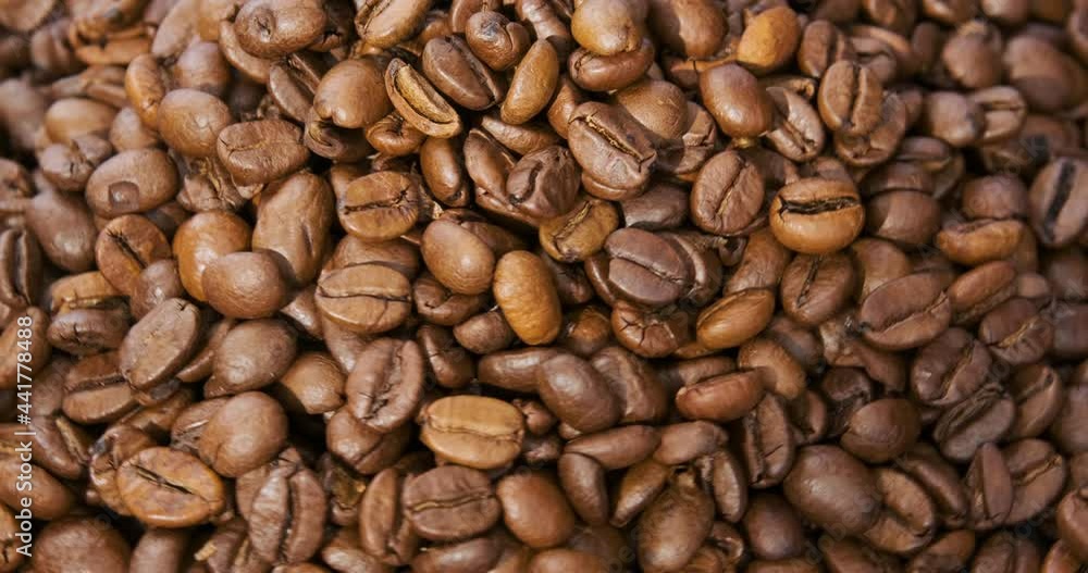 Roasted aromatic coffee beans. Grain coffee. Close up. Top view. Rotating video. Loop motion. Roasted aromatic coffee beans. Grain coffee. Close up. Top view. Rotating video. Loop motion.