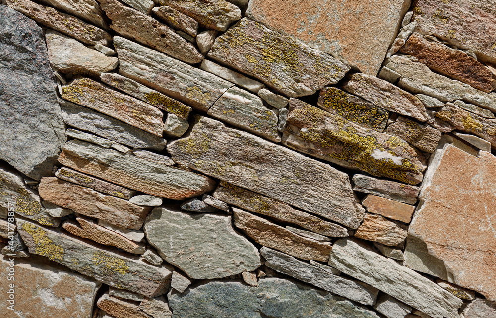 Fototapeta premium A fragment of a stone wall built without the use of cement. Backround for desing.
