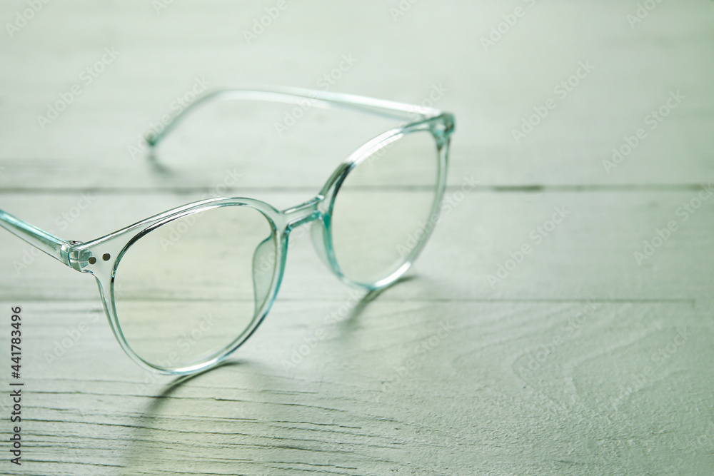 Stylish eyeglasses on color wooden background, closeup Stylish eyeglasses on color wooden background, closeup