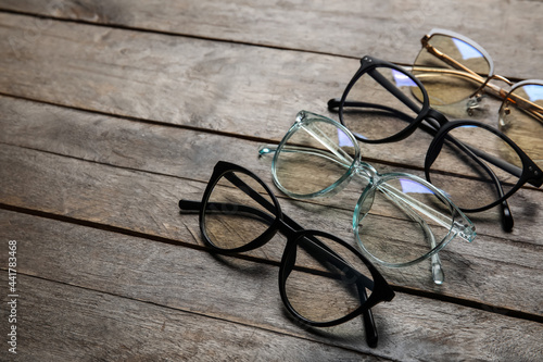 Different stylish eyeglasses on wooden background