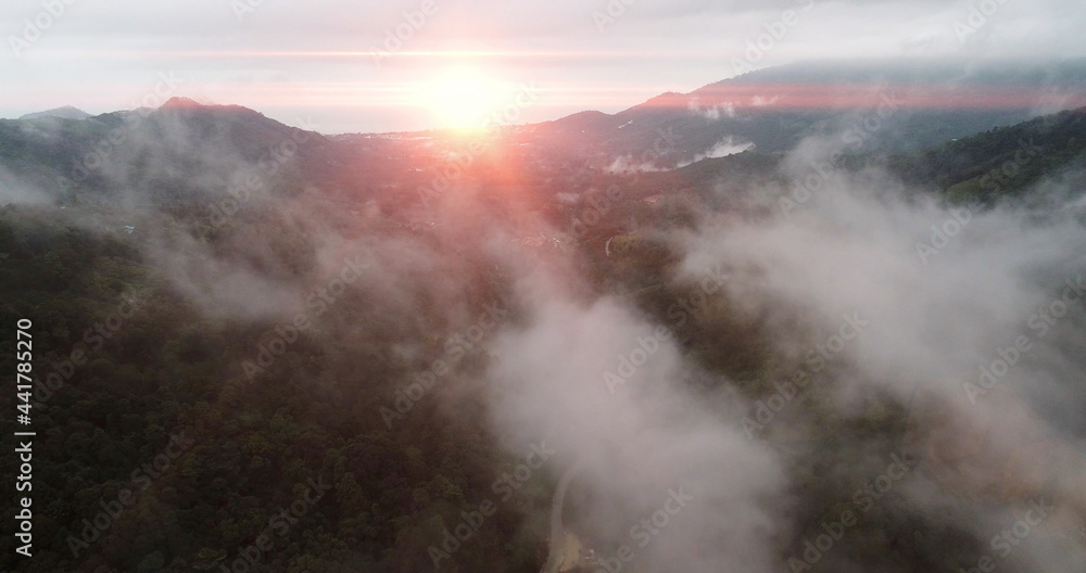 AERIAL. Flying above the clouds over road and rice terraces in Thailand at sunset