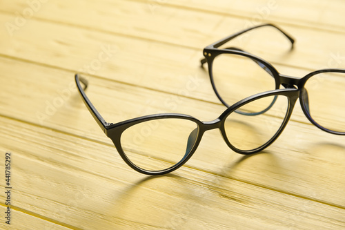 Different stylish eyeglasses on color wooden background, closeup