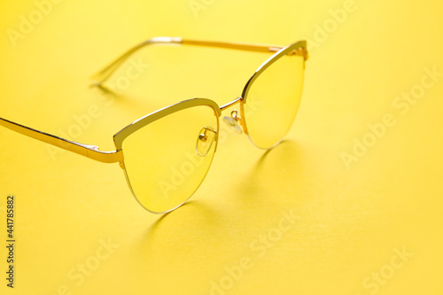 Stylish eyeglasses on color background, closeup